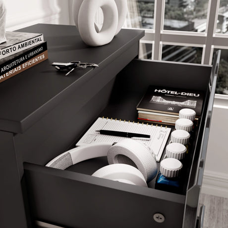 [Black] dresser close-up showing open top drawer with stationery and accessories stored