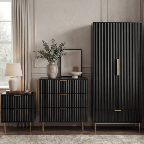 Black bedroom furniture set, including a wardrobe, chest of drawers, and bedside table, placed in a modern room
