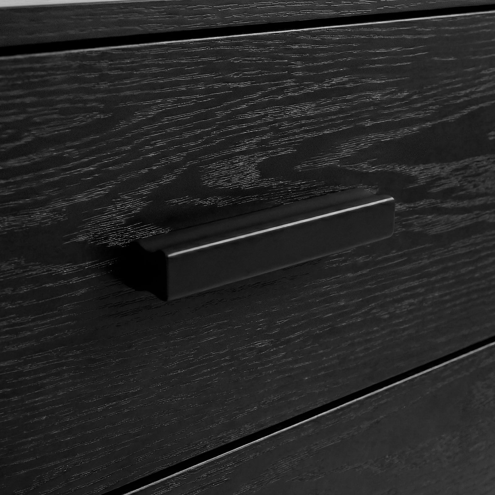 [Black] Close-up of black bar handle mounted on black drawer front of the Blythe five drawer chest