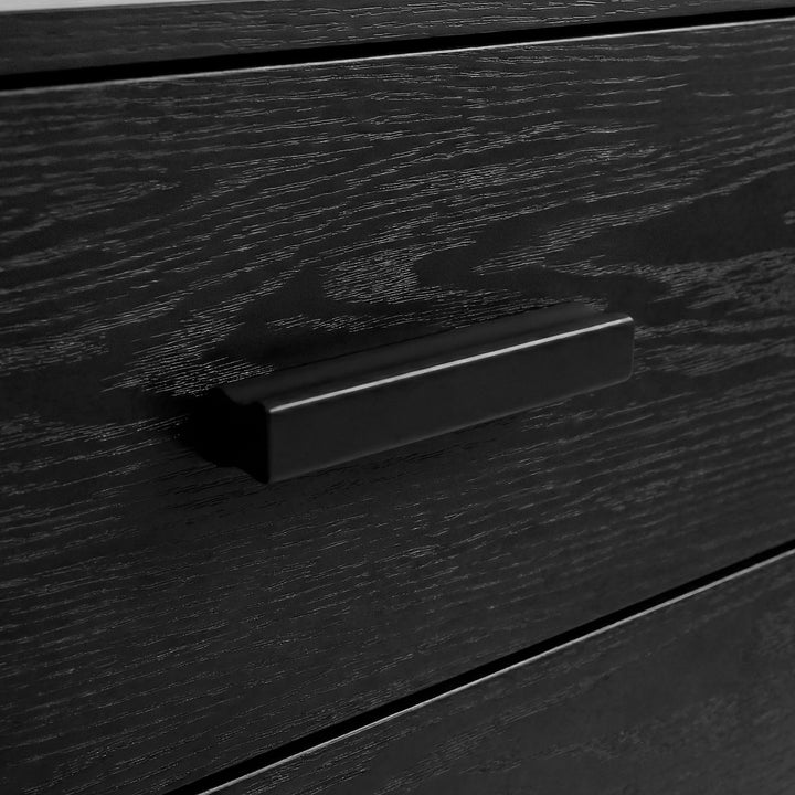 [Black] Close-up of black bar handle mounted on black drawer front of the Blythe five drawer chest