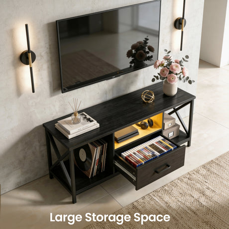 [Black] Calvera TV unit angled view with drawer fully open showing colourful game and book storage, floral decor on top