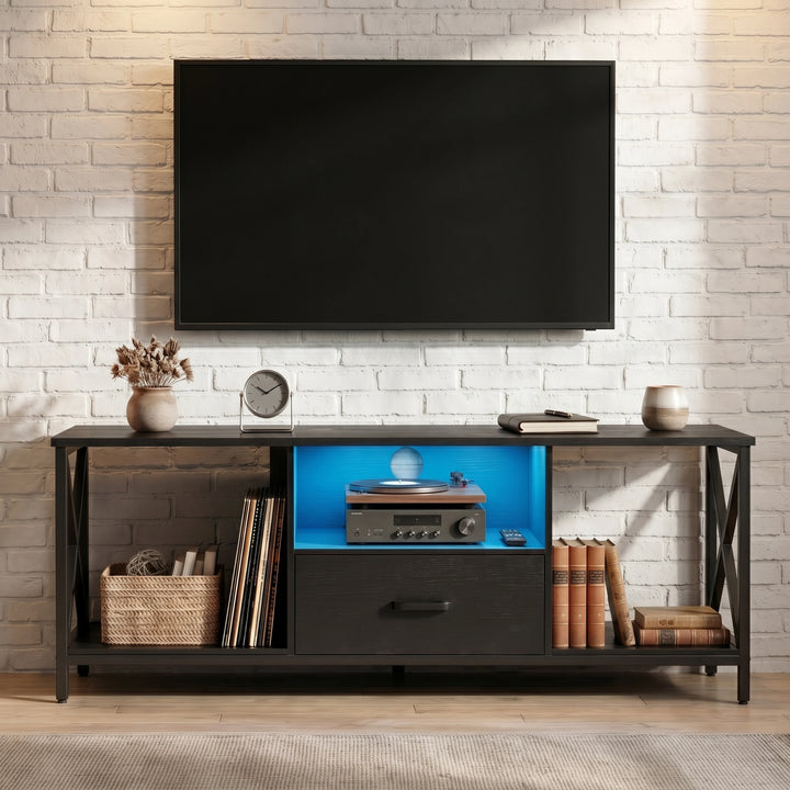 [Black] Calvera TV unit front-on view with blue LED-lit shelf, open storage and X-frame sides against brick wall
