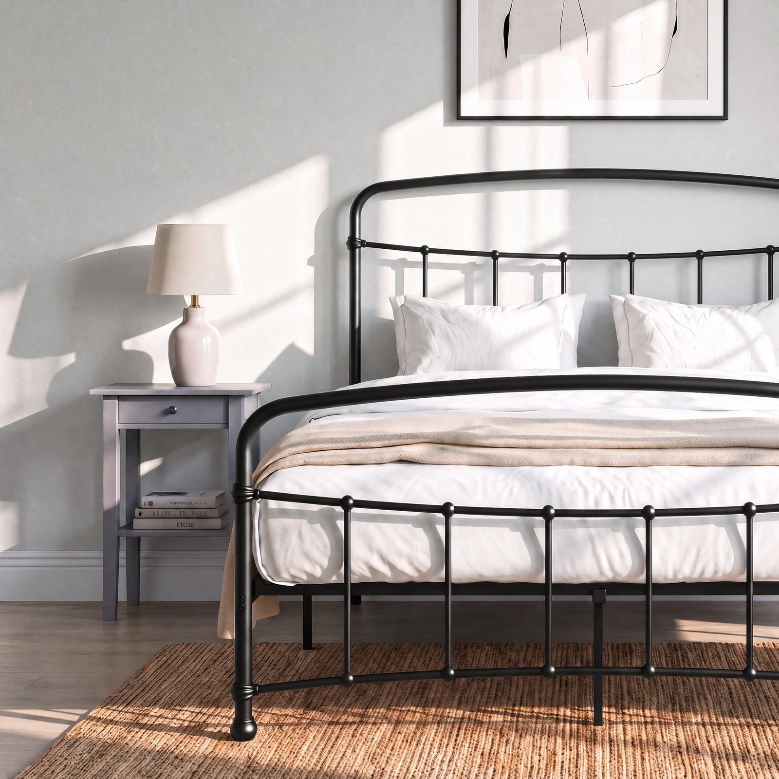[Black | Double] Close view of the black curved front rail, vertical bars and white bedding beside a small table.