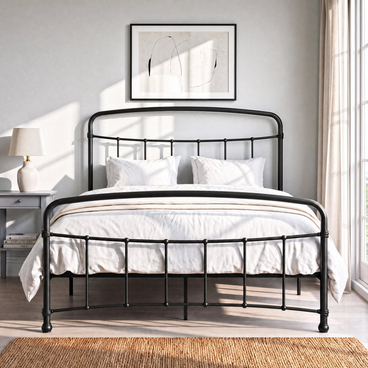 [Black | Double] Front view of a black metal bed frame with curved rails and white bedding in a bright bedroom.