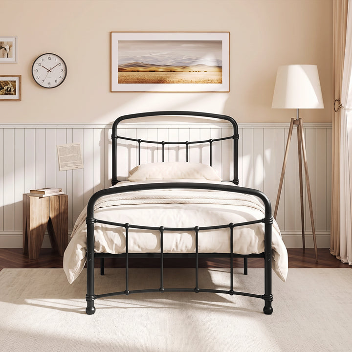 [Black | Single] Front view of a black metal bed frame with curved rails and white bedding in a bright bedroom.