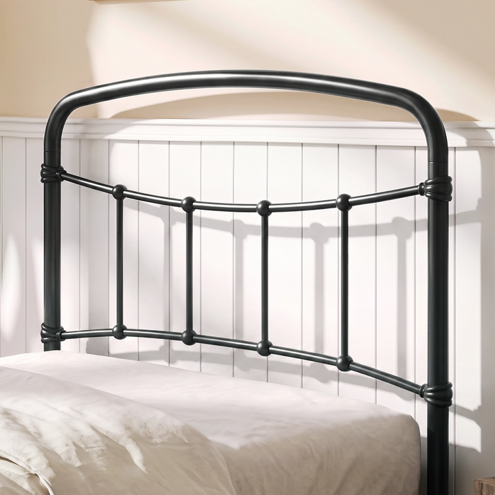 [Black | Single] Close-up of the black curved headboard with vertical bars, white pillows and cream bedding.