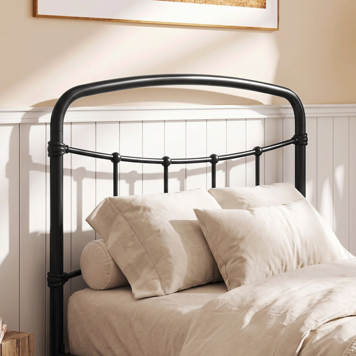 [Black | Single] Close-up of the black curved headboard with vertical bars, white pillows and cream bedding.