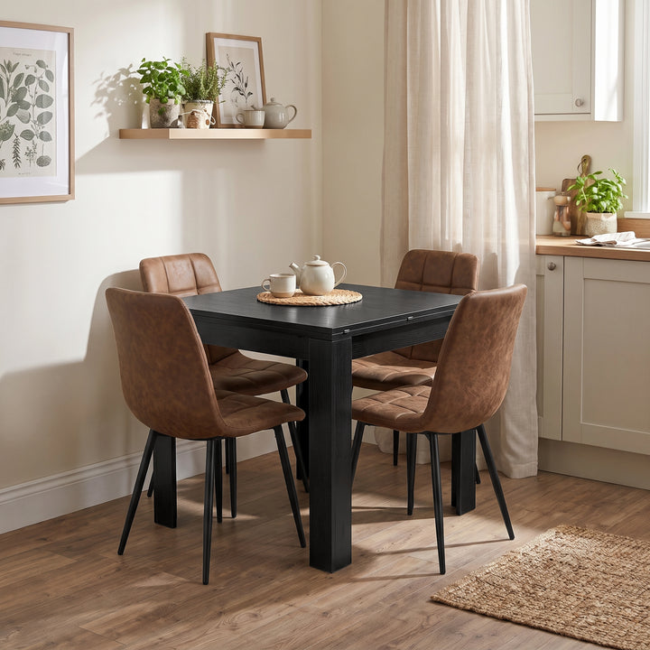 [Black] Closed flip-top dining table with four brown chairs and tea set in a bright open-plan kitchen diner