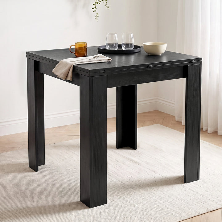 [Black] Close-up wood-grain closed tabletop, steel hinges, wide legs, mug, two glasses, white bowl, napkin and spoon