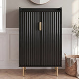 [Black] Fluted Shoe Storage Cabinet shown closed against panelled walls with round mirror, olive plant, and woven basket in a sunlit hallway