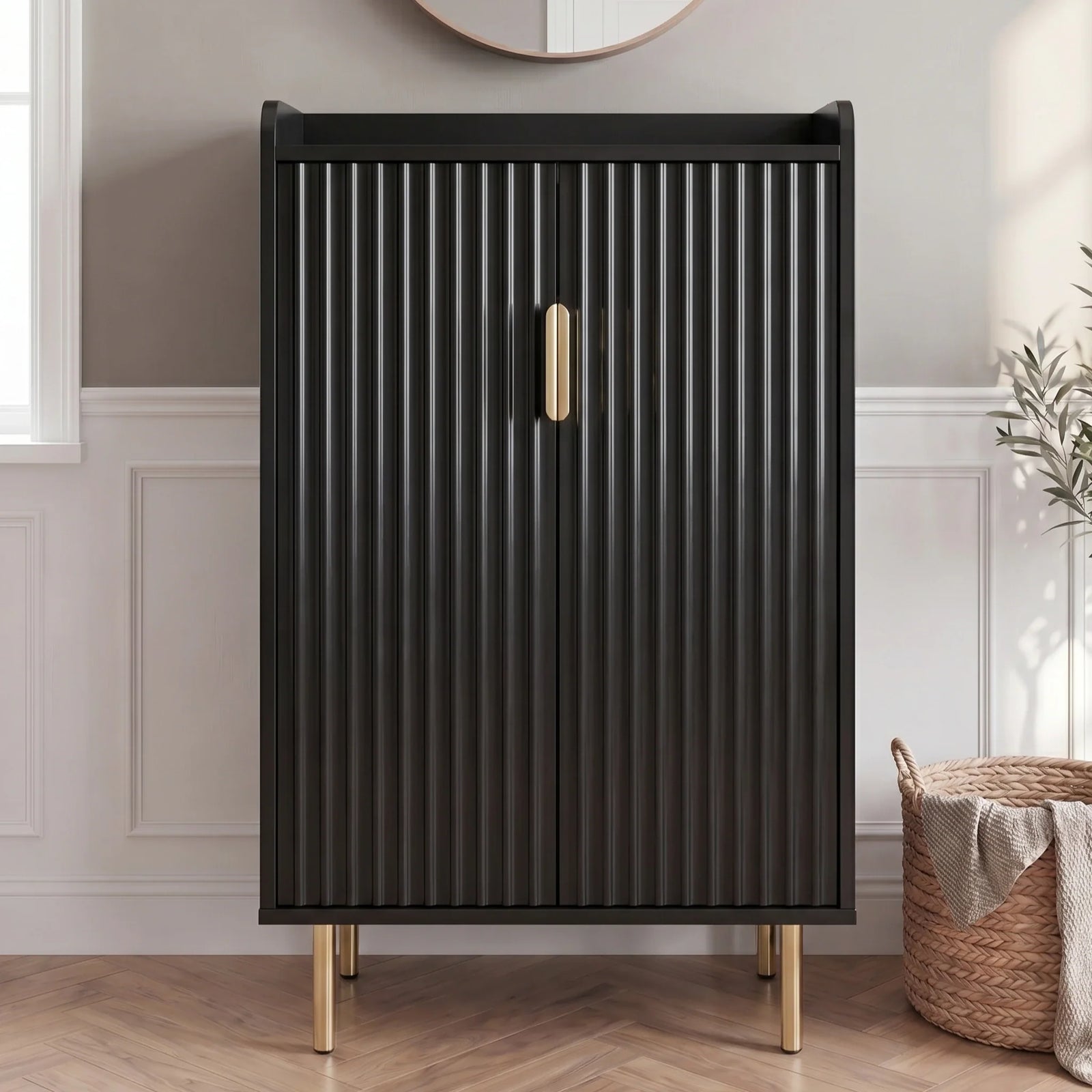 [Black] Fluted Shoe Storage Cabinet shown closed against panelled walls with round mirror, olive plant, and woven basket in a sunlit hallway