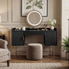 Black makeup vanity table with elegant flutrina design and gold legs, featuring a smooth circular mirror and stylish drawers