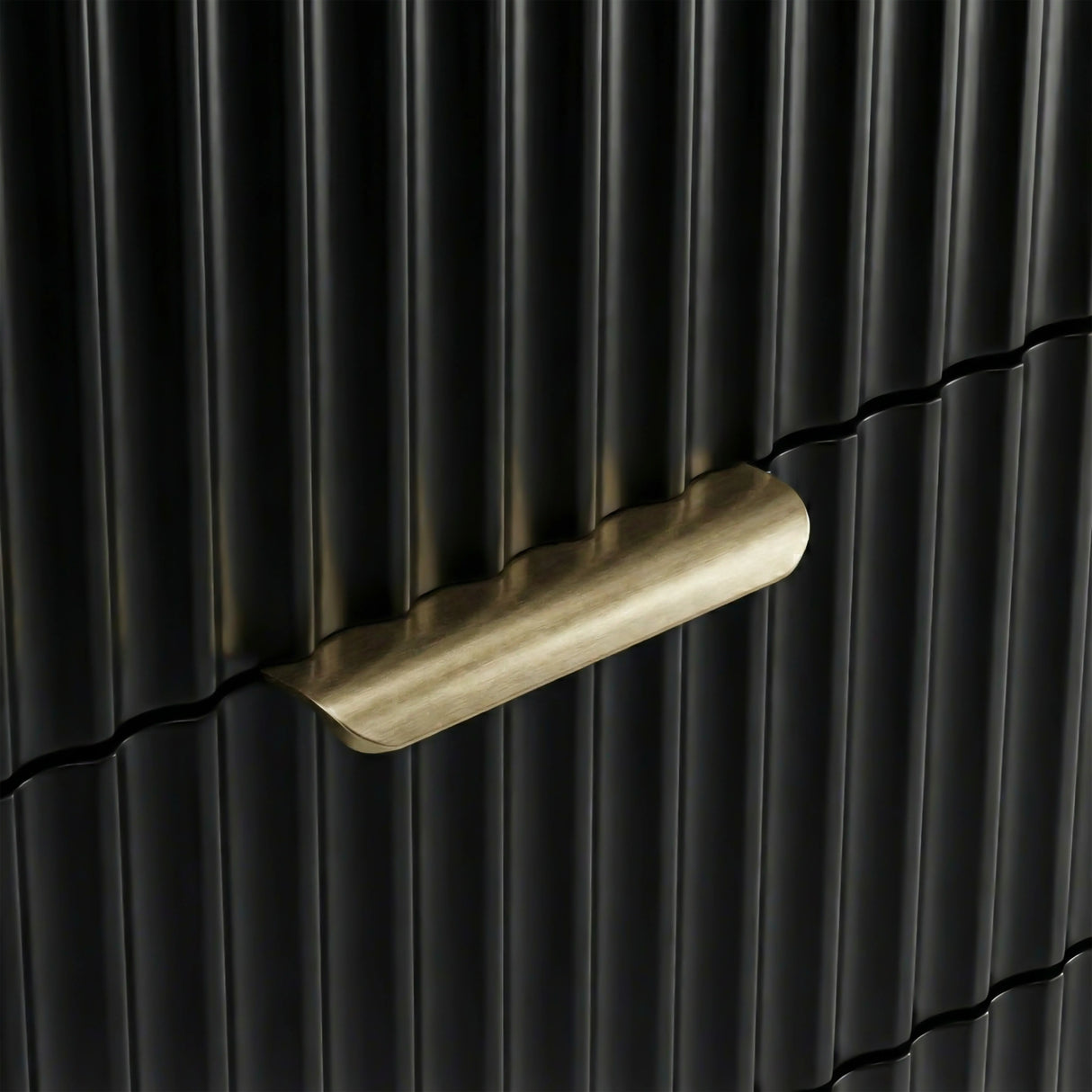 Close detail of black flutrina panel drawer front with painted metal golden handles and a unique design