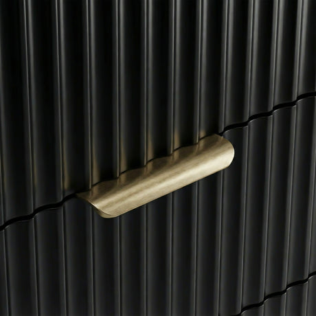 Close detail of black flutrina panel drawer front with painted metal golden handles and a unique design