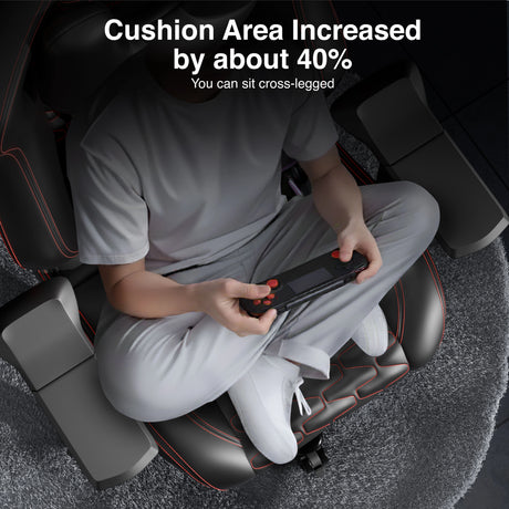 Person using a massage chair with increased cushion area, sitting cross-legged.