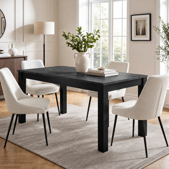 [160cm | Black] Closed table in bright dining room with four cream chairs, vase, stacked books, rug, and window light