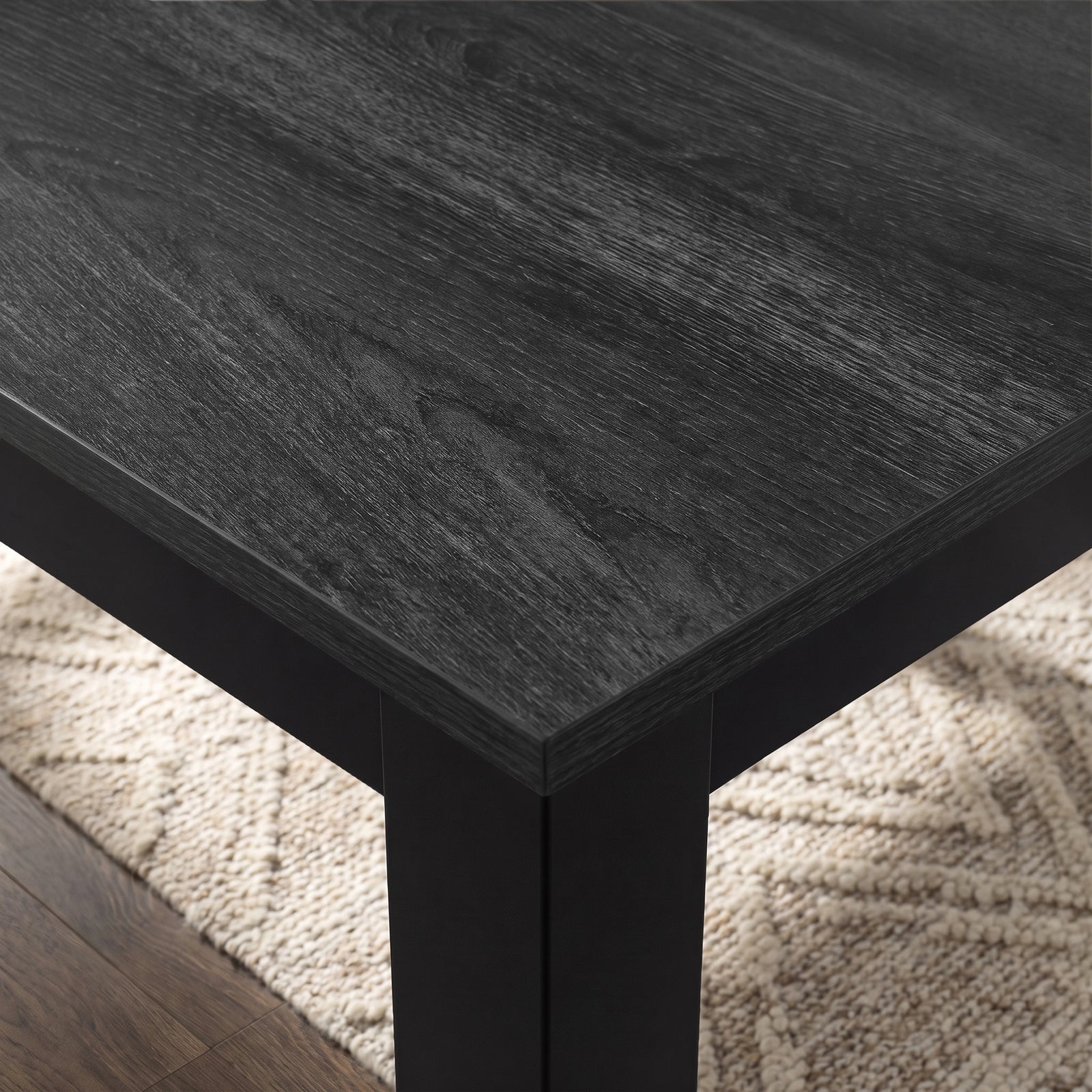 [140cm | Black] Close-up of 18mm thick Hartley extendable dining tabletop and edge, black iron frame and thick square leg