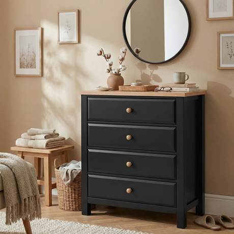 [Black] Haven 4 drawer chest in a warm bedroom setting with round mirror above, wicker basket and soft textiles
