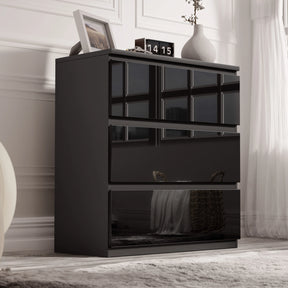 [Black] high gloss 3 drawer chest styled against white panelled wall with vases and clock