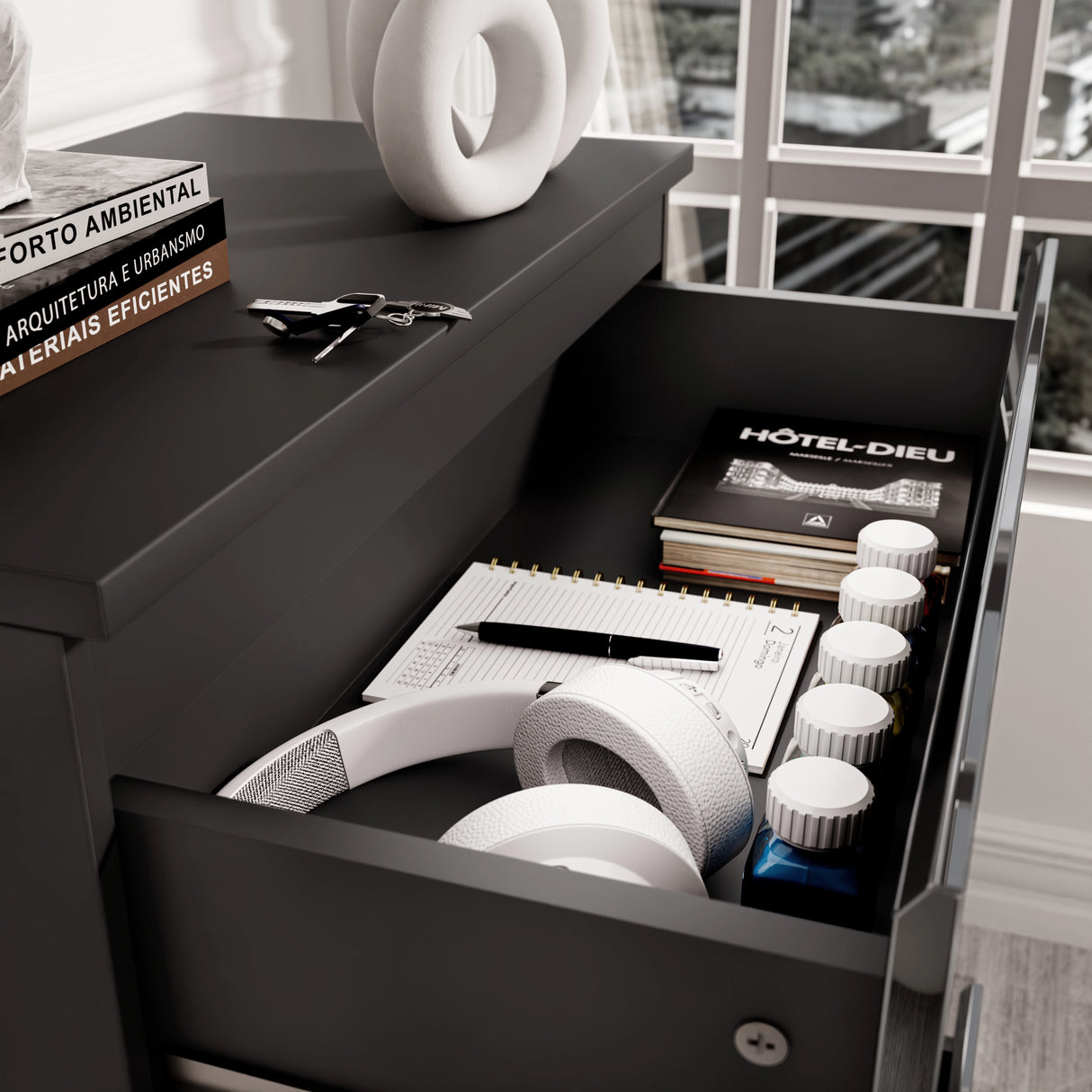 Close-up of drawer in black high gloss bedside table from the bedroom set, storing headphones, books, and accessories.