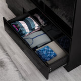 close up of open drawer of black high gloss wardrobe filled with neatly folded clothes