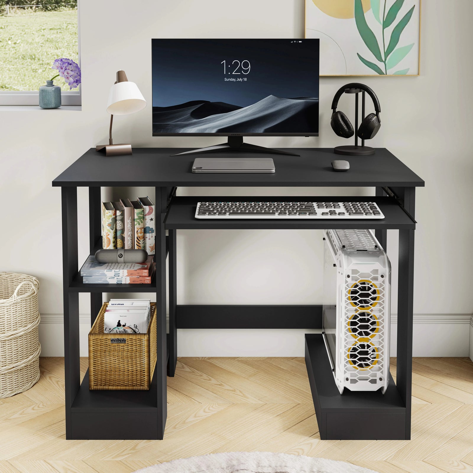 [Black] Small computer desk in black, front view with monitor, lamp, headphones and PC tower on right base shelf