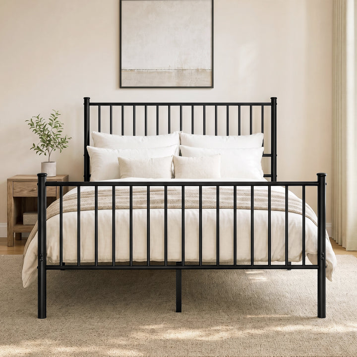 [Black | King] Front view of black metal king bed with white bedding, bar headboard and footboard, centre leg, lamp and plant