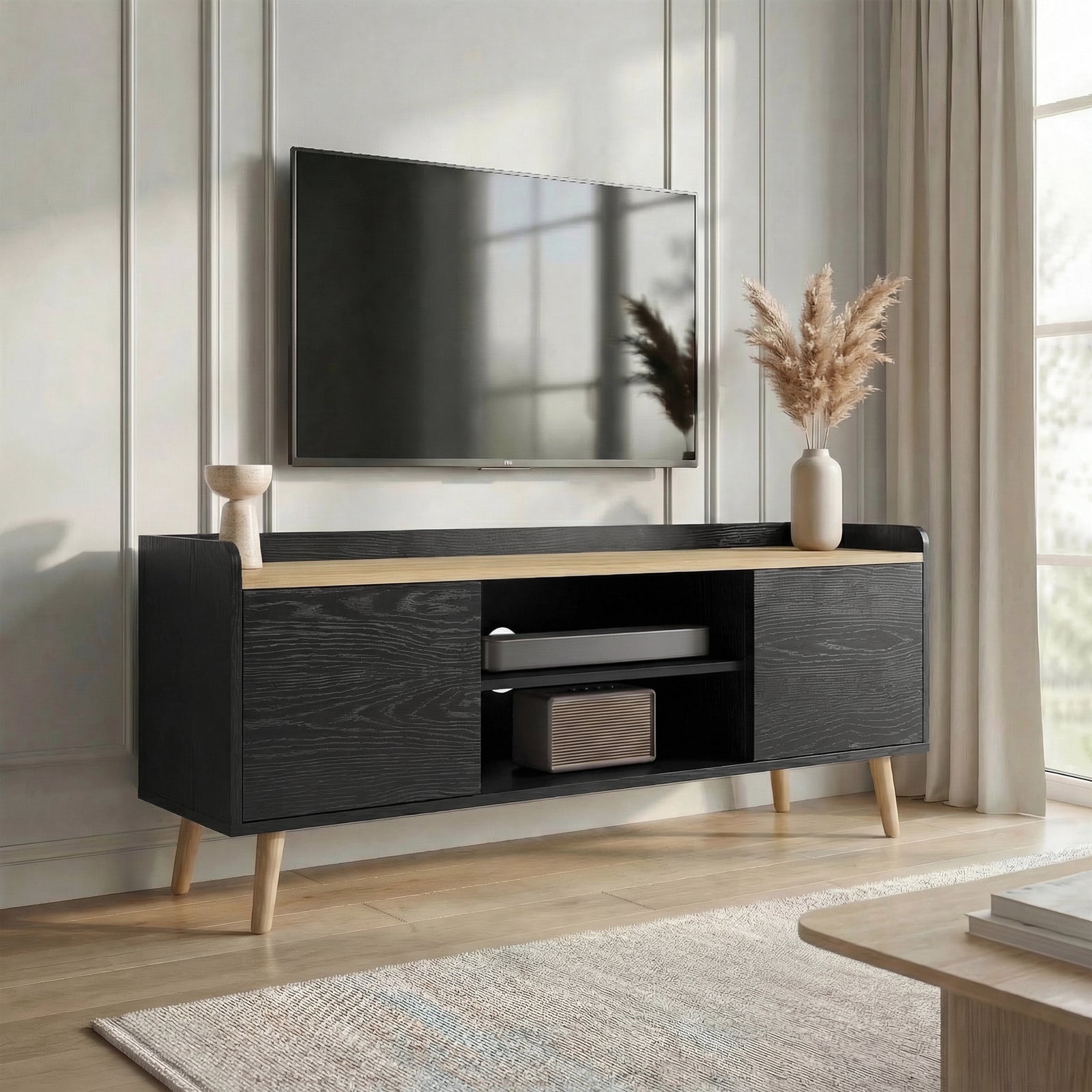 [Black | 112 cm] Larvik styled at an angle in a sunlit panelled room with wall-mounted TV, decorative vases, and soundbar in centre shelves