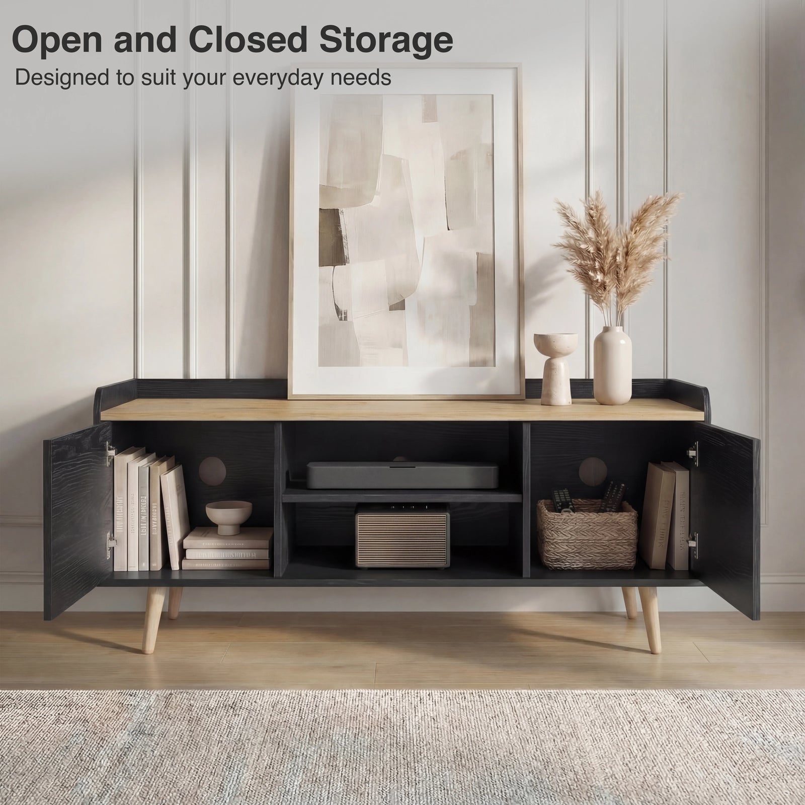 [Black | 112 cm] Larvik front view with both cabinet doors open revealing books, speaker, woven basket, and cable management holes in panelled room