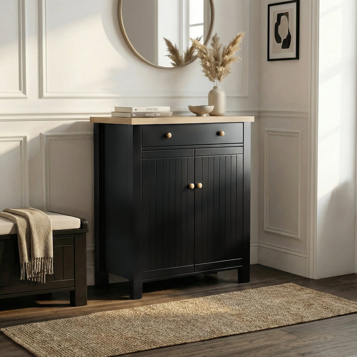 [Black] Linra shoe cabinet with grooved double doors, oak knobs, top drawer, and natural oak top styled in a bright hallway