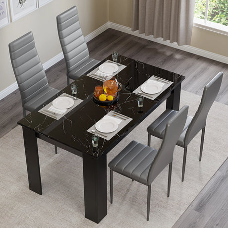 top-down view of kitchen table and chairs with grey leather upholstery and black marble finish table top set for casual dining