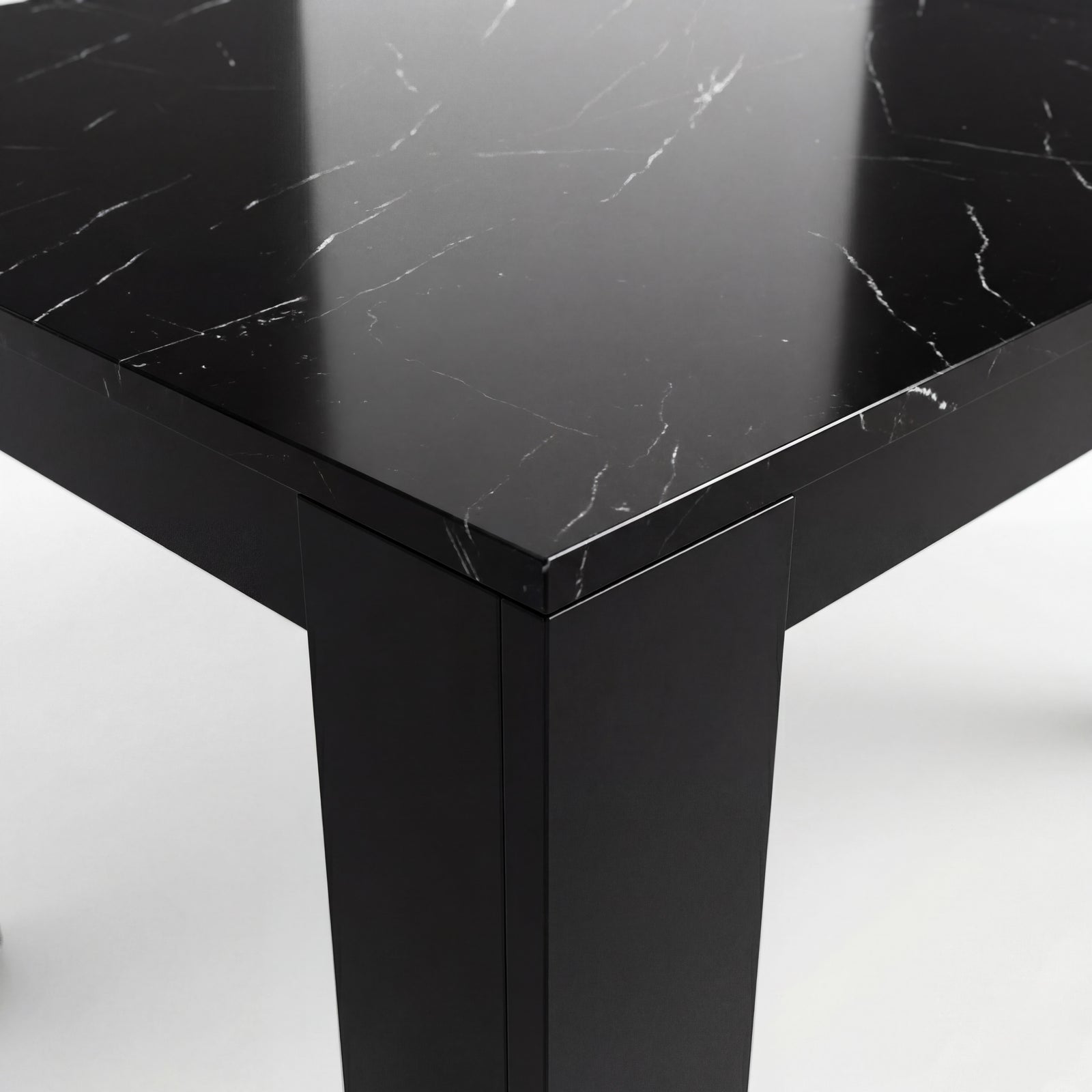 [Black Marble] Close-up of the glossy marble-effect tabletop corner; white veining runs above a thick black L-shaped leg.