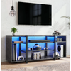 [Black Marble] Zelumi TV stand in a gaming room with blue LED-lit shelves holding consoles, VR headset, soundbar, and accessories below a wall-mounted TV
