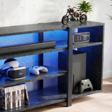 [Black Marble] Zelumi TV stand right-side close-up showing blue LED-lit shelves with console, clock, VR gear, and game cases in the lower compartments