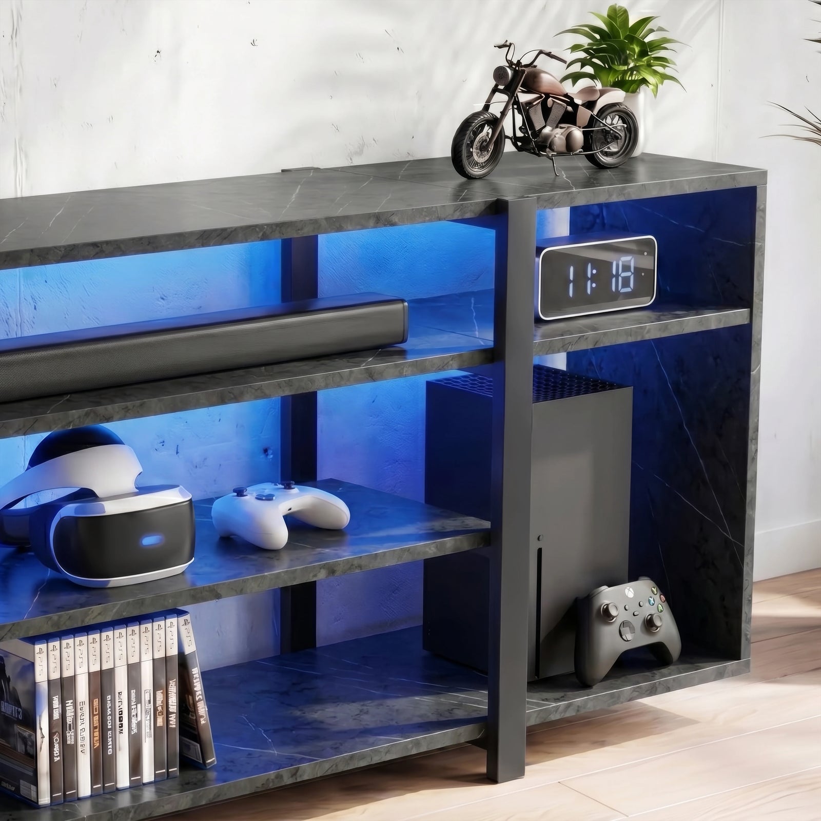 [Black Marble] Zelumi TV stand right-side close-up showing blue LED-lit shelves with console, clock, VR gear, and game cases in the lower compartments