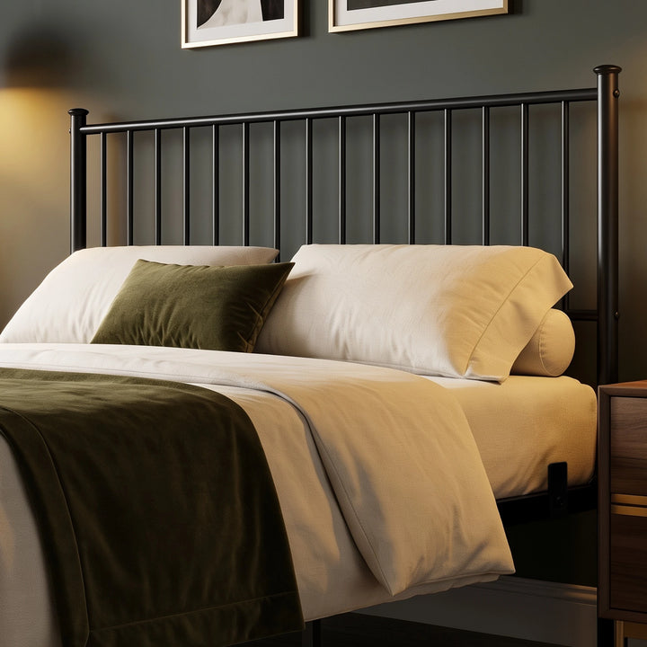 [Black | King] headboard close-up showing vertical metal bars, capped posts, cream pillows, and an olive cushion.