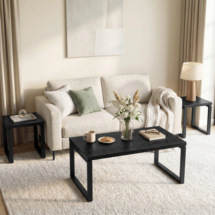 [Black] Nestline coffee table styled in a soft room with beige chairs, curtains, framed art, and rug