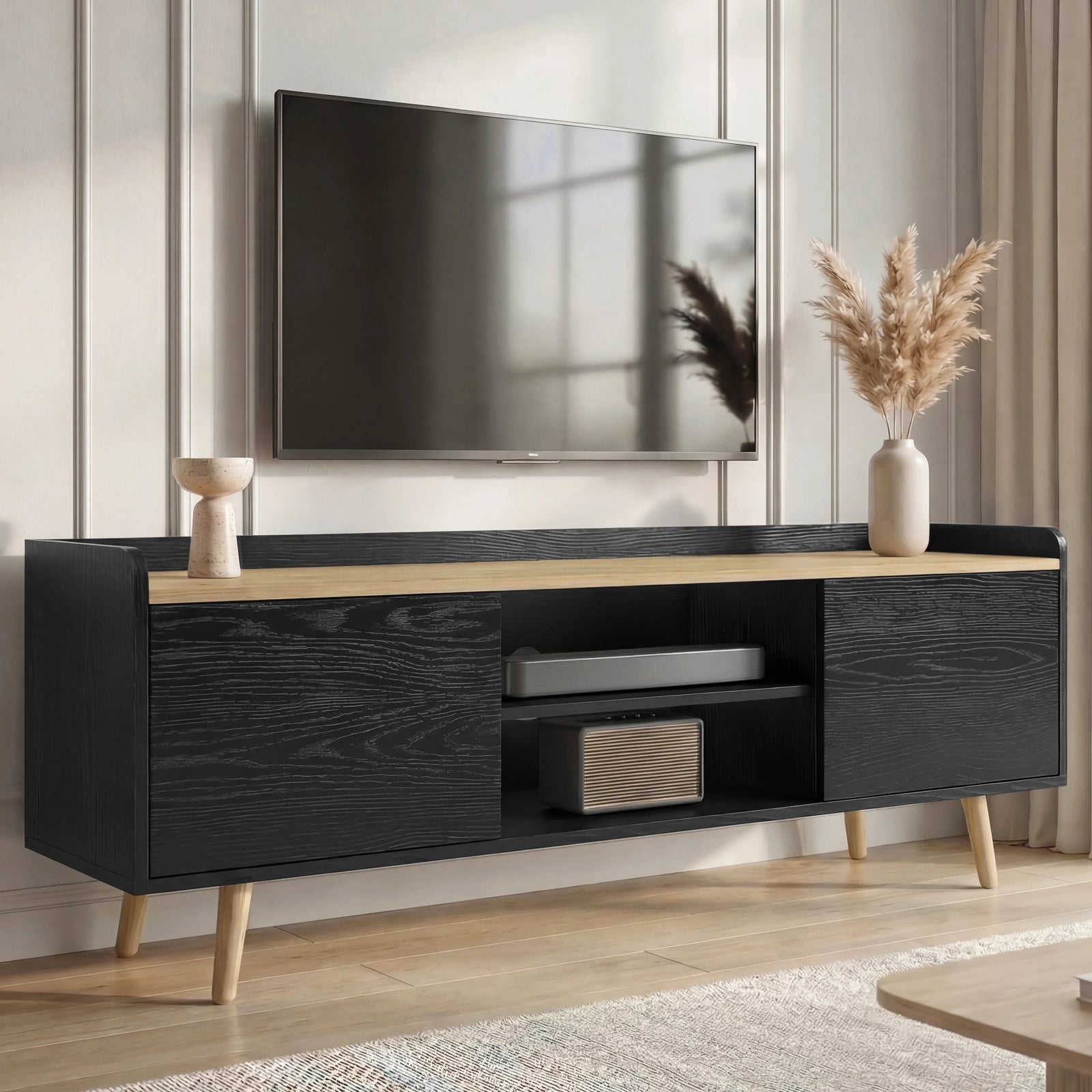 [Black] Larvik TV unit in lifestyle scene with pampas vase, books and basket inside centre cubby of low cabinet
