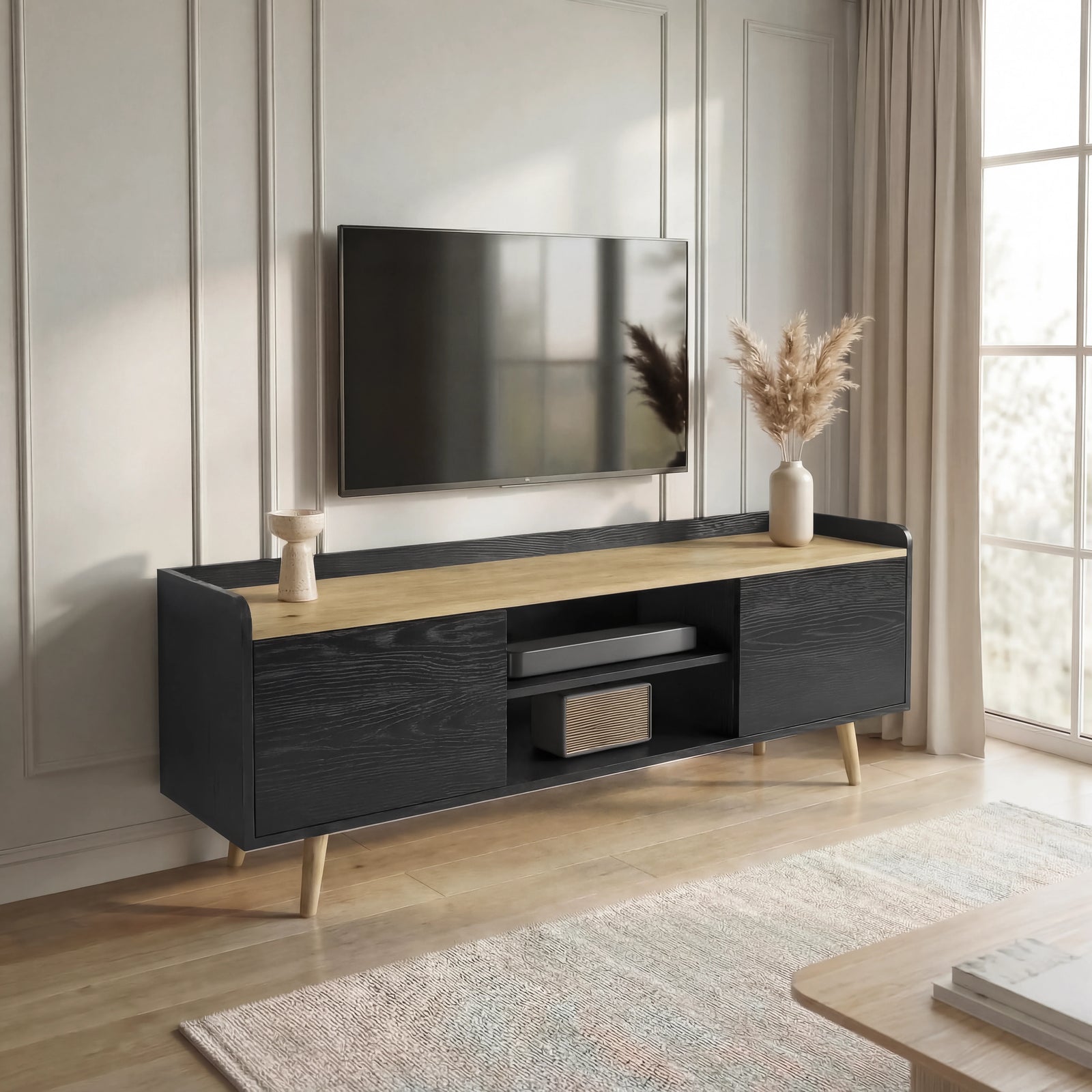 [Black] Larvik TV unit wide living room placement with TV above, cream rug below and pampas vase on right