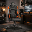 [Black + Orange] gaming chair with the Xstriker logo on the headrest, backrest, and lumbar support, positioned in a modern, dimly lit home office setup.