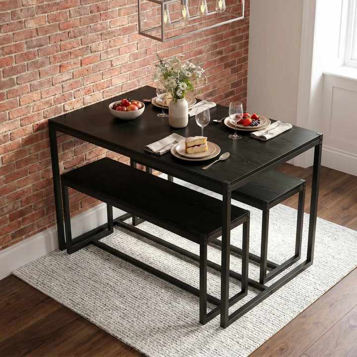 [Black] Orvak dining table with two benches tucked underneath in an industrial brick-wall dining room, styled with fruit bowl and flower vase