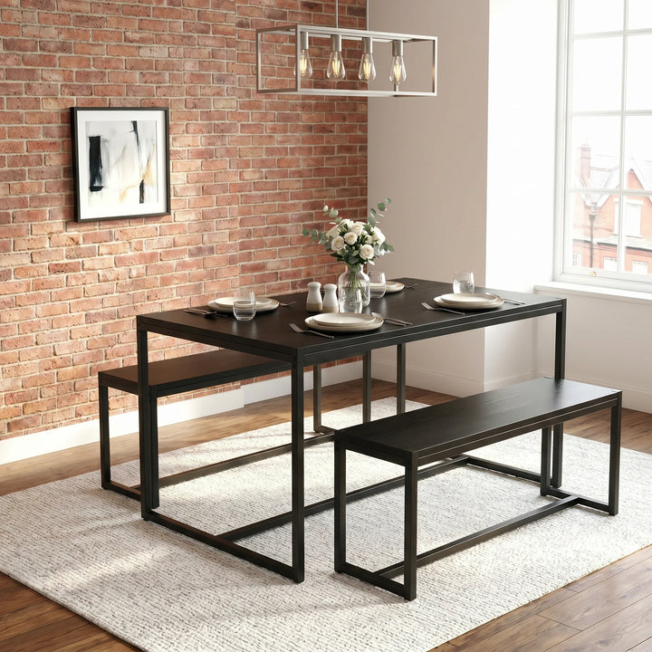 [Black] Orvak dining table and two benches in an industrial brick-wall dining room with place settings and a white rose centrepiece