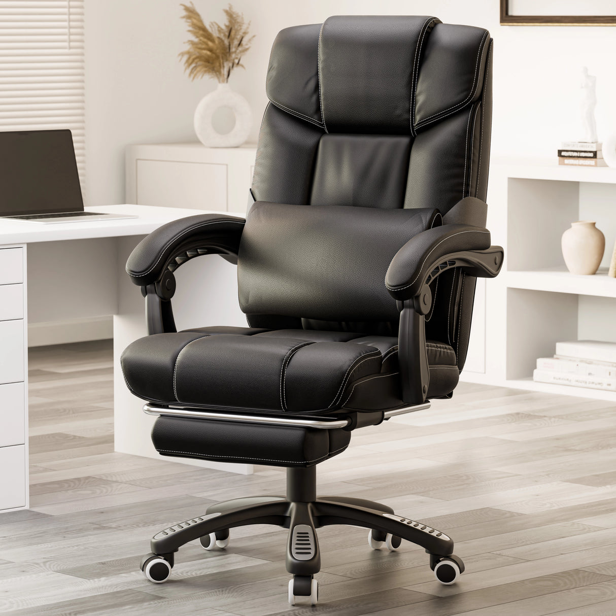 black leather office chair with footrest and lumbar pillow placed beside a wooden desk in home office