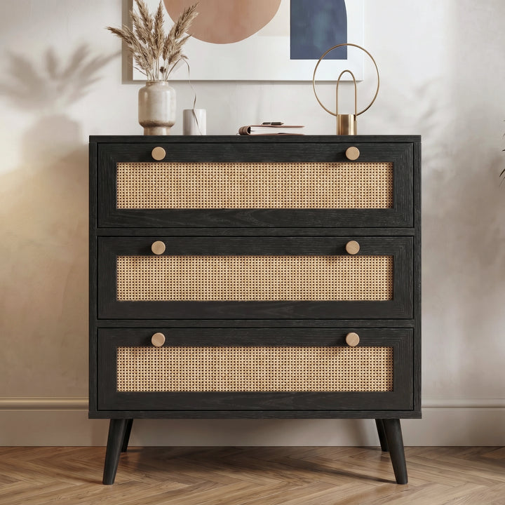 [Black] Rattan chest of drawers straight-on front view with three full-width rattan panels and round wooden knobs