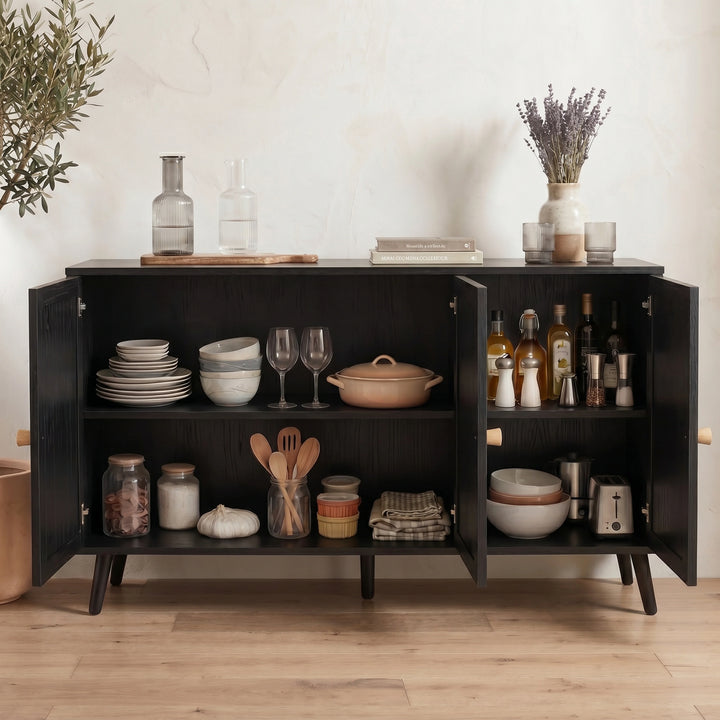 [Black] Rattan sideboard with all three doors open showing shelves styled with dishes, cookware, and pantry jars