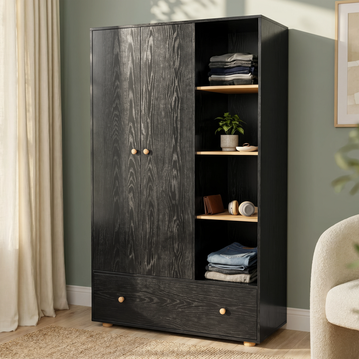 [Black] Selby wardrobe angled lifestyle view showing two-door section, open shelves with folded clothes and plant, and large drawer