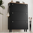 Tall three door black shoe cabinet with oak top and bag on side hook, two knobs per drawer in traditional-modern style.