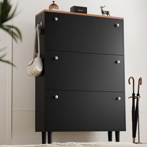 Tall three door black shoe cabinet with oak top and bag on side hook, two knobs per drawer in traditional-modern style.