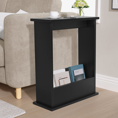 Black side table with books and a vase in a living room setting