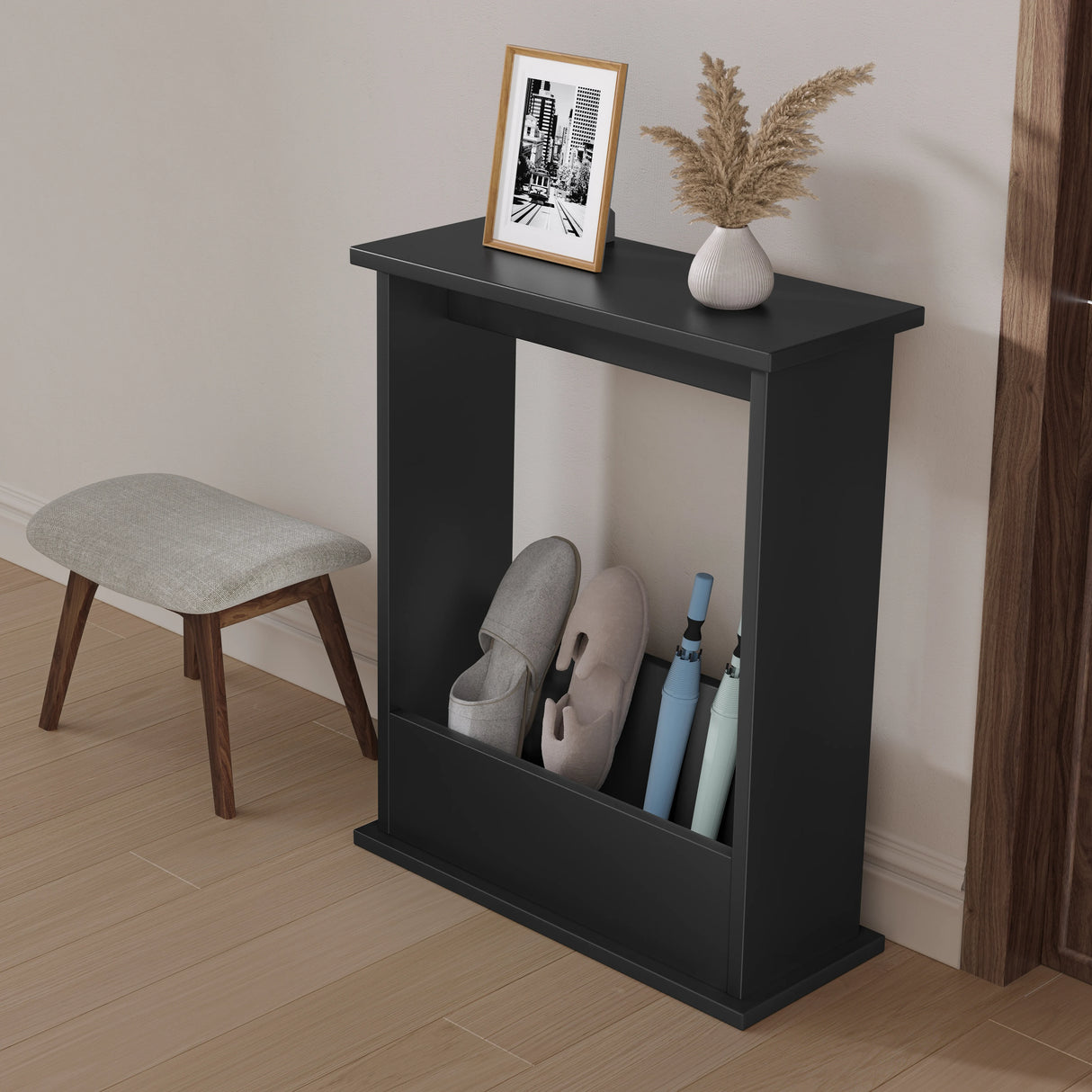 Black shoe rack with shoes, a picture frame, and a vase on top in a room setting.